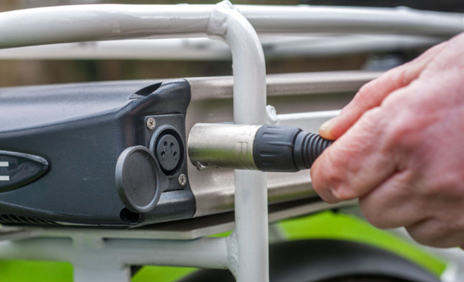 Personne qui recharge la batterie de son vélo électrique
