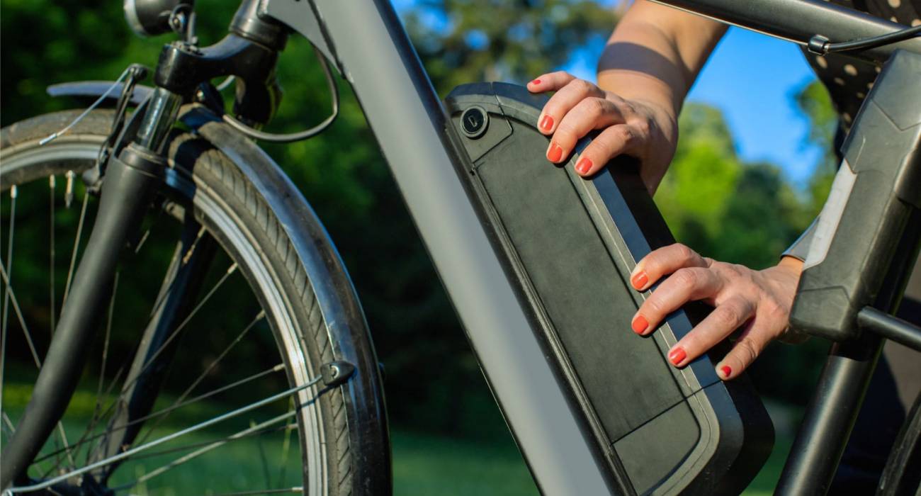 Personne qui place sa batterie sur son vélo